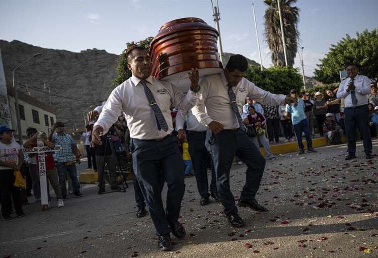 Los "bailarines de la muerte" cargan un ataúd en un funeral en Huacho, Perú / AFP 