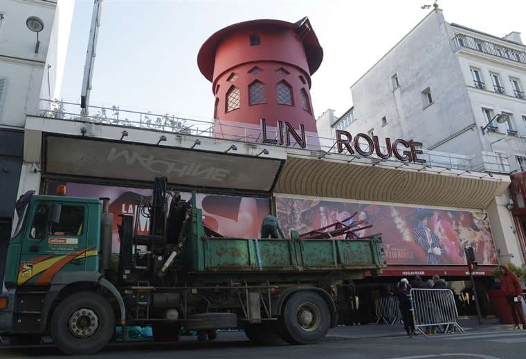 Trabajadores cargan las aspas del molino de viento del Moulin Rouge en París / AFP 