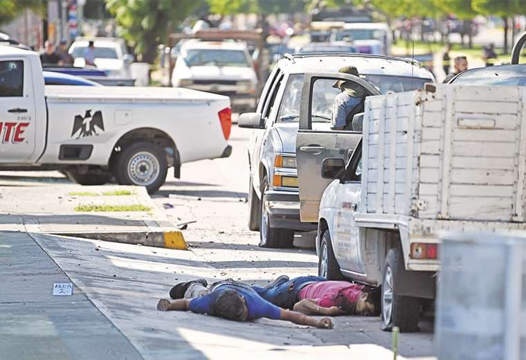 Dos cuerpos yacen en una calle de Culiacán donde se desató una batalla campal con los narcos. Foto: AFP