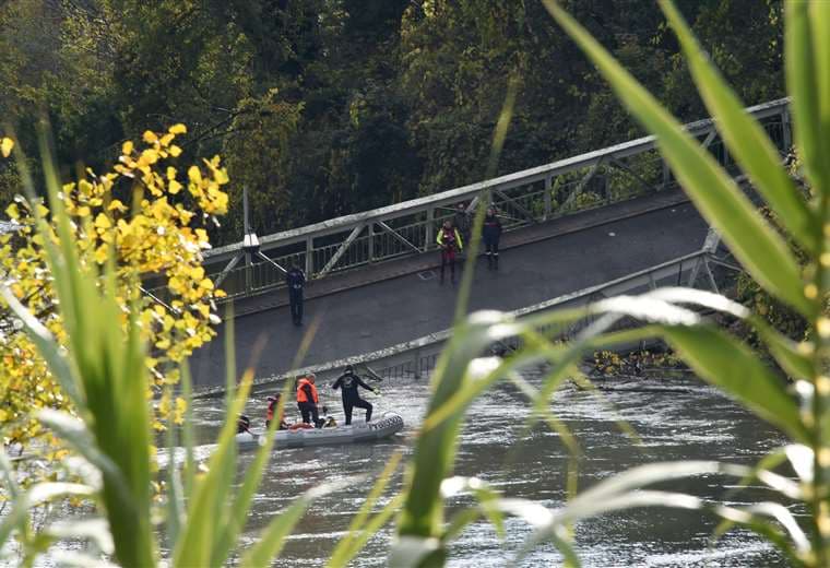 Rescatistas ayudan a las personas heridas en el puente. Foto AFP 